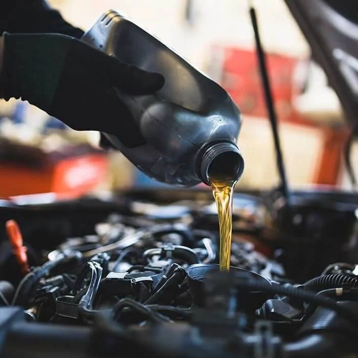 Filling engine oil into a Toyota engine during a scheduled service